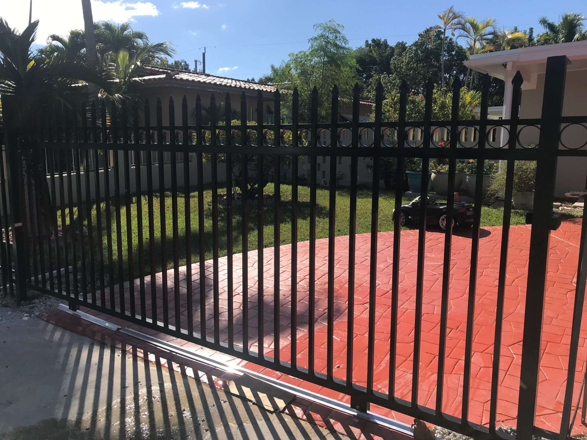 Black custom metal driveway gate installed by Griffiths Metal Products in South Florida